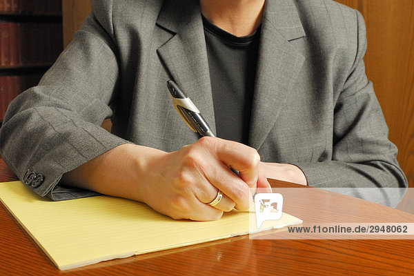 Geschäftsfrau auf einen Block Papier schreiben