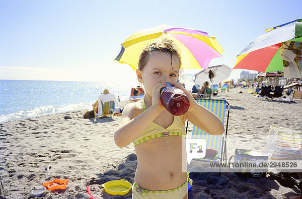 Kleines Mädchen am Strand trinken Saft  Miami  Florida
