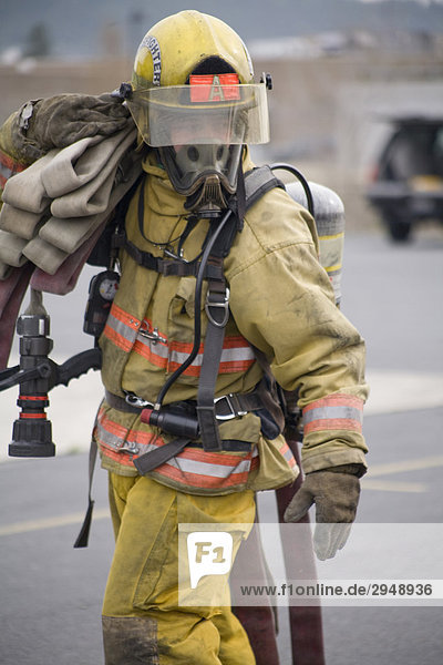 Feuerwehrmann trägt Schlauch an Feuerschein  Spokane  Washington