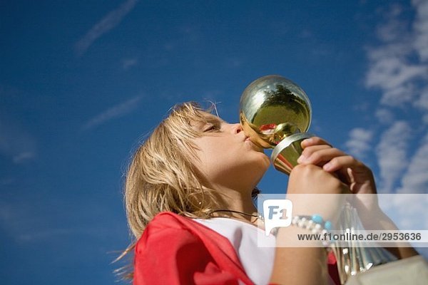 Soccer player kissing trophy cup
