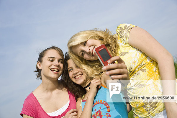 Drei junge Mädchen machen Fotos von sich  Flachwinkelansicht