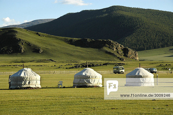 Drei Jurten Ger in der Steppe vor bewaldetem Grebirgszug Orkhon Wasserfall Mongolei