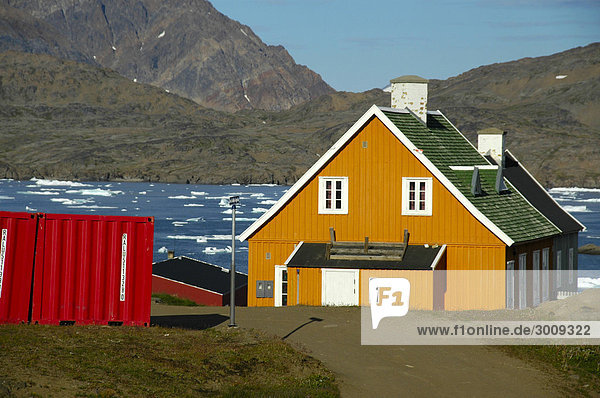 Buntes Haus vor Fjord in der Siedlung Ammassalik Ostgrönland