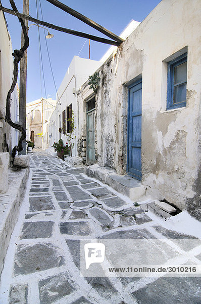 Alte Holztüren mit verwitterter grüner und blauer Farbe in einer Gasse mit Steinboden in Naxos  Kykladen  Griechenland  Europa