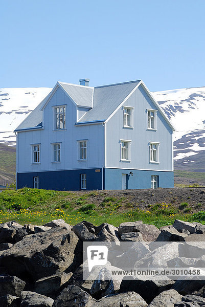 House with snow-covered mountains in the background Grenivik  Iceland  low angle view