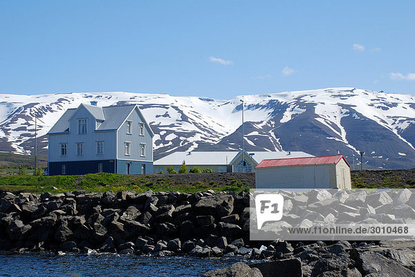 Houses in North Iceland  snow-covered mountains in the background Grenivik  Iceland  low angle view