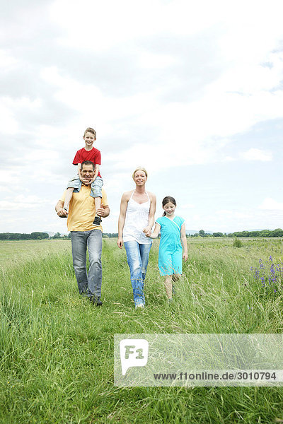 Family with two children on a meadow  front view