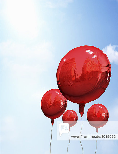 Red balloons in sky