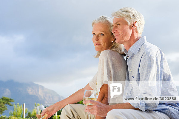 Mittelalterliches Paar entspannt sich draußen bei einem Glas Wein