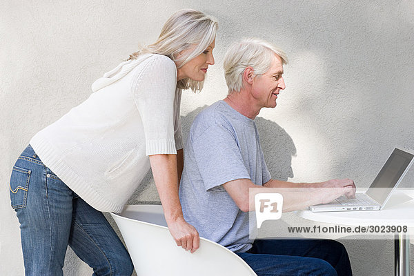 Middle aged couple using laptop