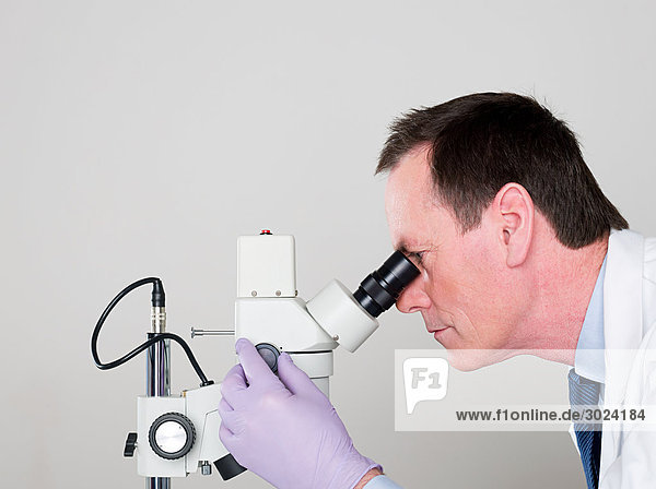 Male scientist using a microscope