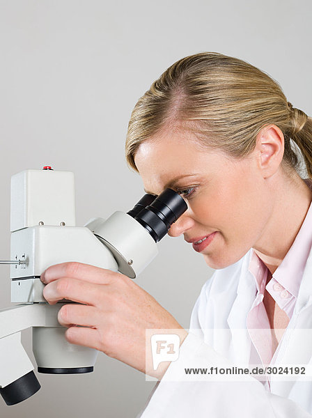 Female scientist using a microscope