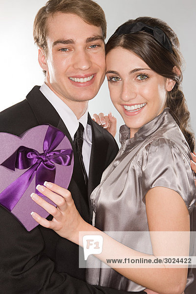 Romantic couple holding a heart shaped box