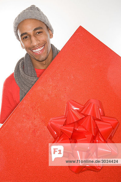 Mann mit einem großen roten Geschenk