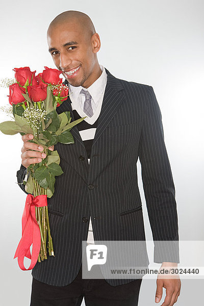Lächelnder Mann mit einem Rosenstrauß