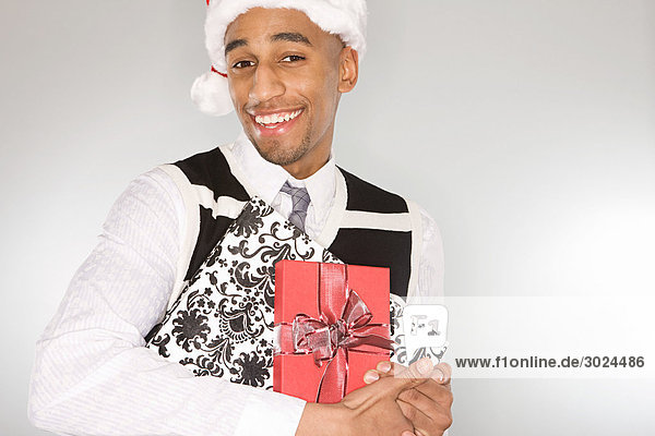 Smiling man holding christmas gifts