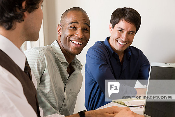Three male colleagues laughing