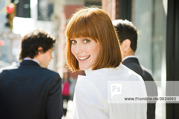 Smiling ginger haired woman on the street