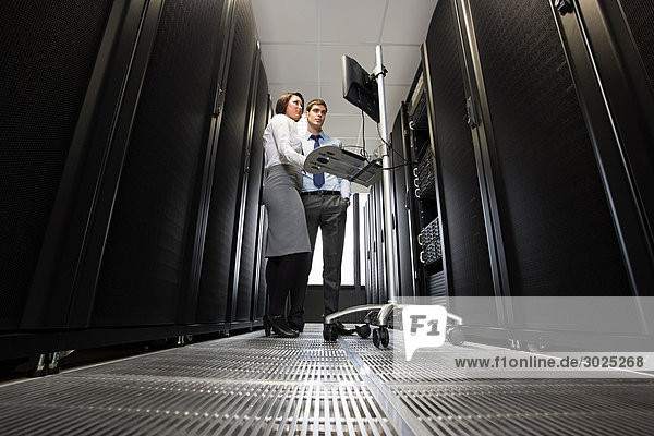 Two computer technicians working on servers