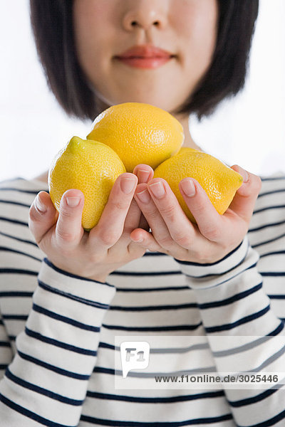 Frau hält Zitronen in der Hand
