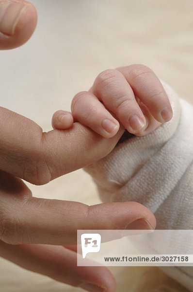 Baby Boy (3 Wochen) mit dem Finger  Nahaufnahme