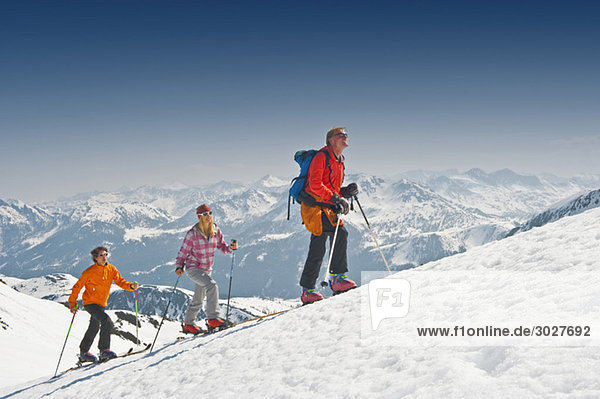 Austria  Salzburger Land  Altenmarkt  Zauchensee  Three persons cross country skiing in mountains  side view