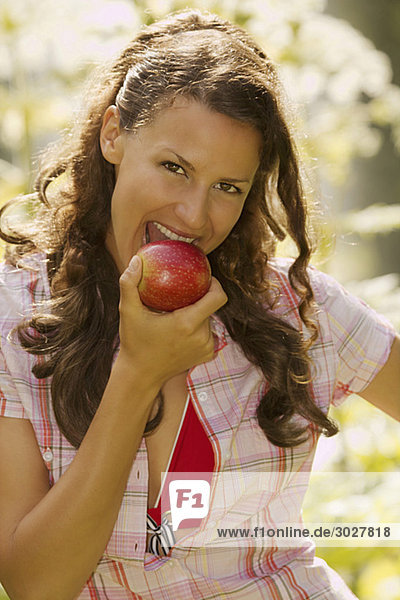 Junge Frau isst Apfel  Porträt