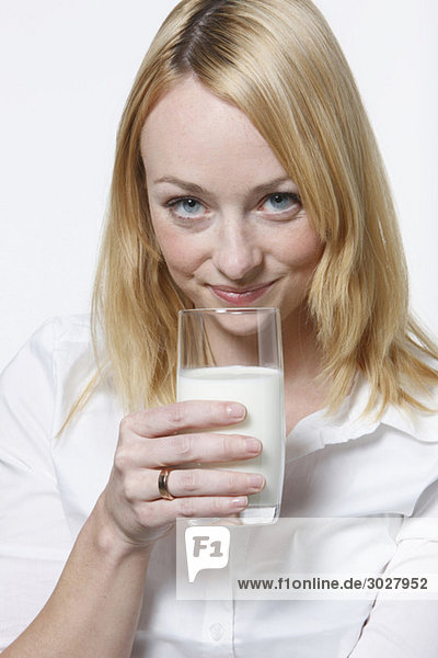 Junge Frau trinkt ein Glas Milch  Portrait