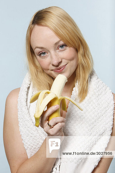 Junge Frau mit Banane  lächelnd  Porträt