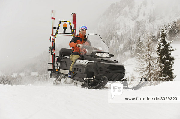 Italien  Südtirol  Mann fährt Schneemobil
