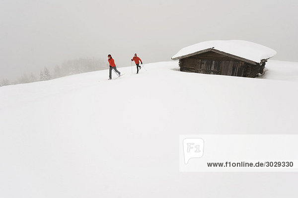 Italien  Südtirol  Paar Langlauf neben der Hütte