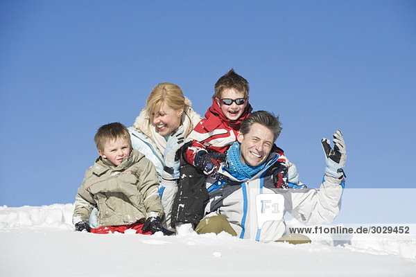 Italien  Südtirol  Seiseralm  Familie im Schnee sitzend  Portrait