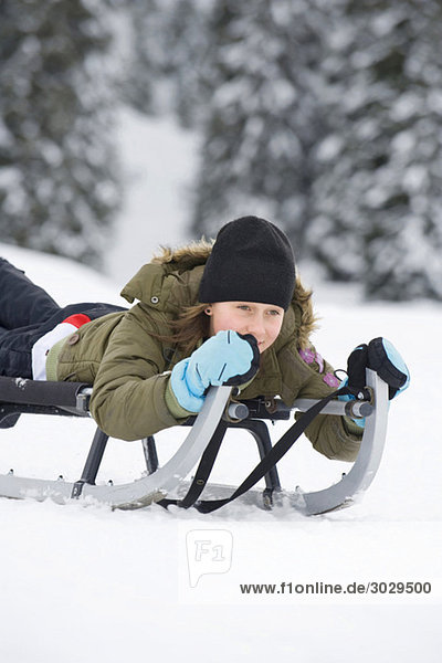 Italy  South Tyrol  Seiseralm  Girl (12-13) sledding downhill  portrait