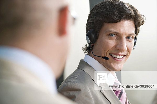 Man wearing headset  Businessman in foreground