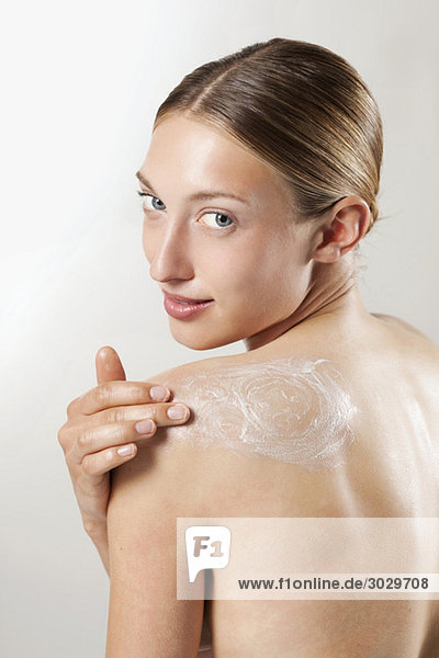 Young woman applying beauty cream  portrait