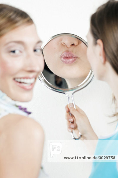 Young women looking into mirror