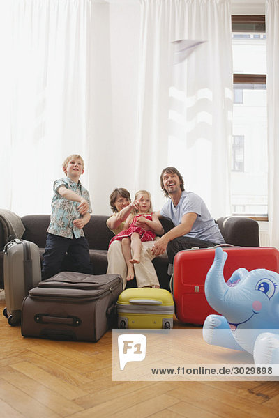 Familie sitzt auf dem Sofa  Junge (8-9) wirft Papierflugzeug in die Luft