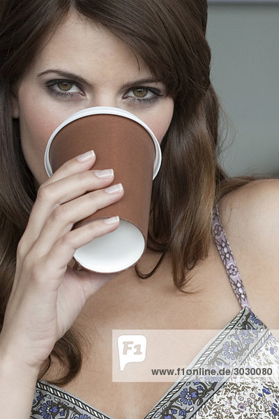 Junge Frau trinkt Tasse Kaffee  Portrait  Nahaufnahme