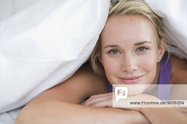 Close-up of a woman lying on the bed and smiling