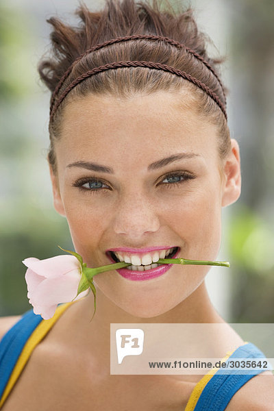 Mode-Modell hält Rose zwischen den Zähnen