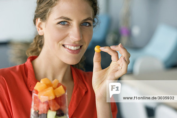 Portrait of a woman holding fruit salad