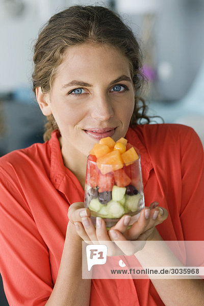 Portrait of a woman holding fruit salad