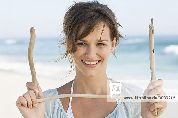 Woman holding sticks and smiling