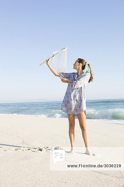 Woman holding a fishing net on the beach