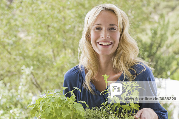 Woman carrying plants and smiling