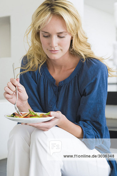 Frau mit einem Teller Obstsalat