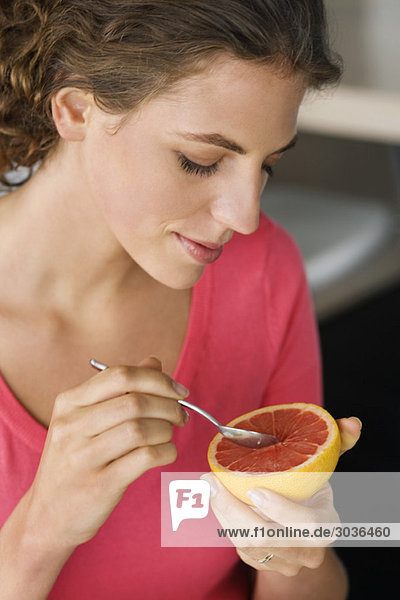 Close-up of a woman eating grapefruit
