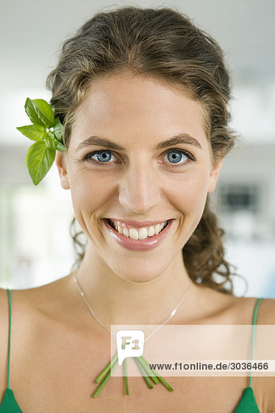 Woman smiling and wearing vegetable leaves in the kitchen
