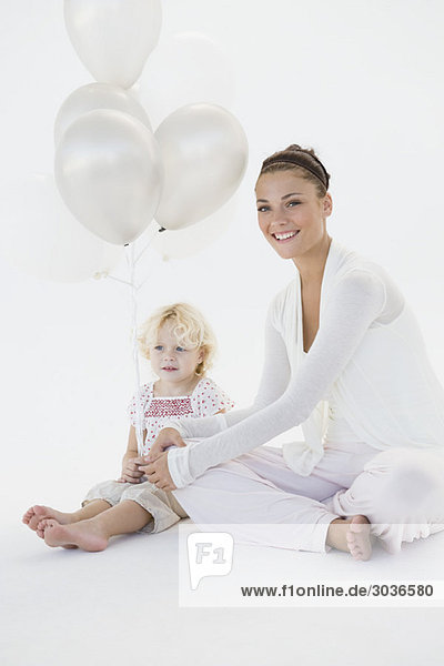 Frau gibt ihrer Tochter Luftballons