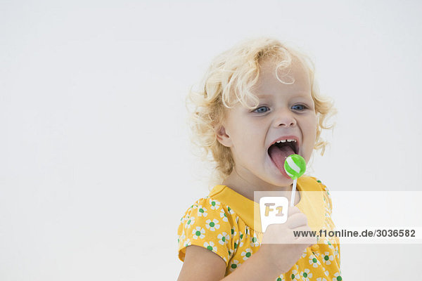 Girl licking green lollipop